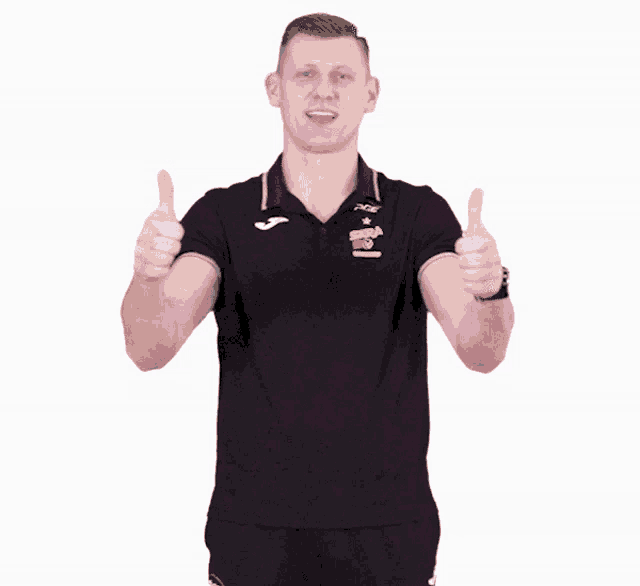 a man wearing a black polo shirt that says pge on it gives two thumbs up