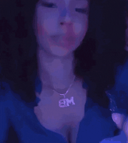 a blurry image of a person giving the middle finger in purple light