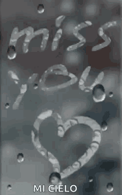 a heart is drawn on a window with the words `` miss you '' written in water drops .
