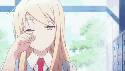 a blonde anime girl with long hair and red eyes is covering her eyes with her hand .