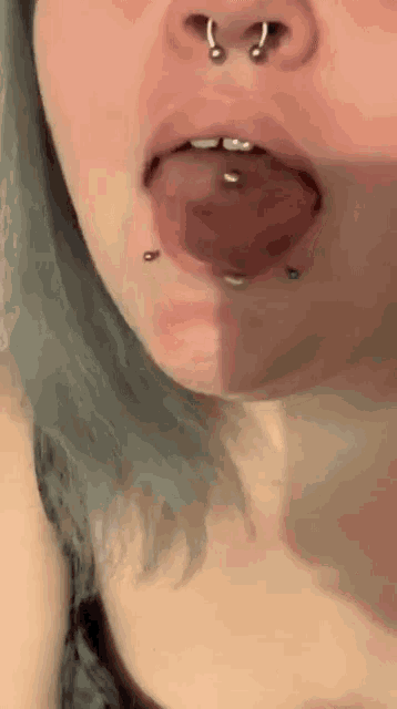a close up of a woman 's mouth with piercings