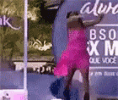 a woman in a pink dress is standing next to a sign that says bso xm