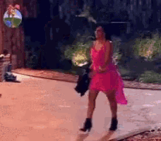 a woman in a pink dress is walking down a sidewalk