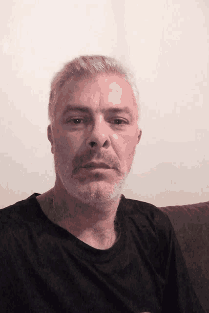 a man with gray hair and a beard has a tattoo on his neck that says ' i '