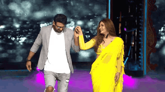 a man in a suit and a woman in a yellow dress are dancing together