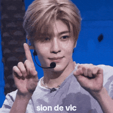 a man wearing a microphone and a shirt that says " sion de vic " on it