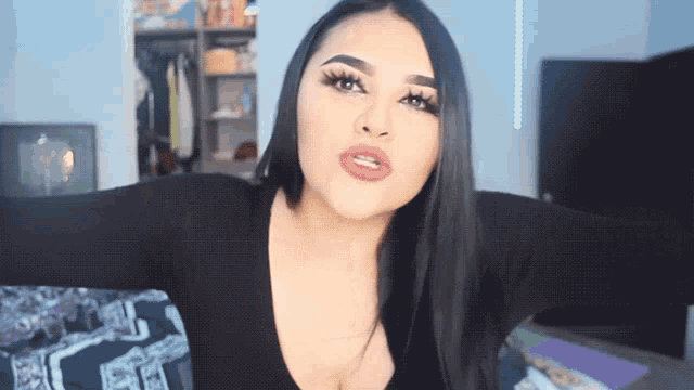 a woman with long black hair is making a funny face with her arms outstretched