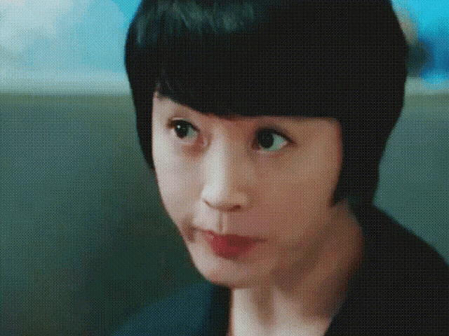 a close up of a woman 's face with short hair
