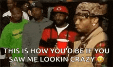 a group of men are standing in a line and a man is holding a red cup and talking to another man .