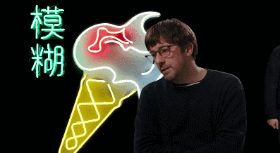 a man stands in front of a neon ice cream cone with chinese characters on it