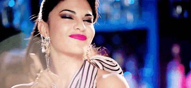 a woman wearing a striped top and earrings is making a face
