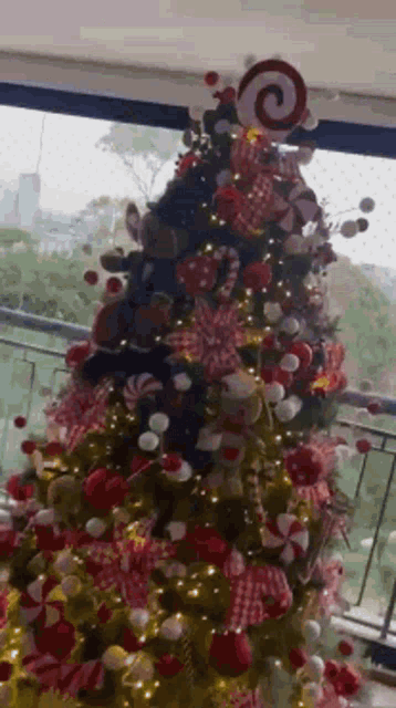 a christmas tree decorated with red and white decorations and a lollipop on top