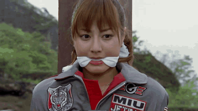 a woman wearing a jacket that says miu jets on it