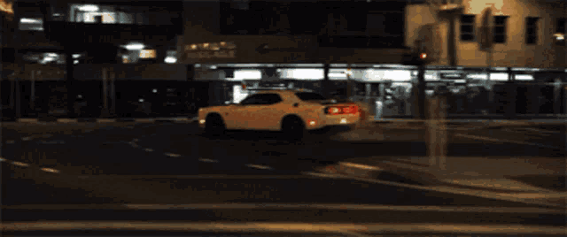 a white dodge challenger is doing a burnout in a parking garage at night .