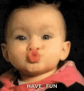 a baby is making a funny face and blowing a kiss with his tongue .