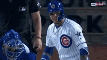 a baseball player in a cubs uniform is talking to a referee