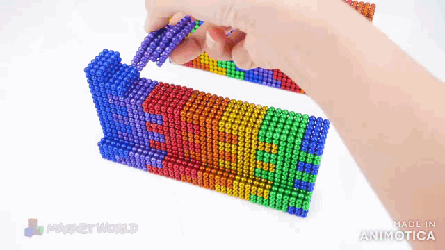 a person is playing with a rainbow colored toy made by magnet world