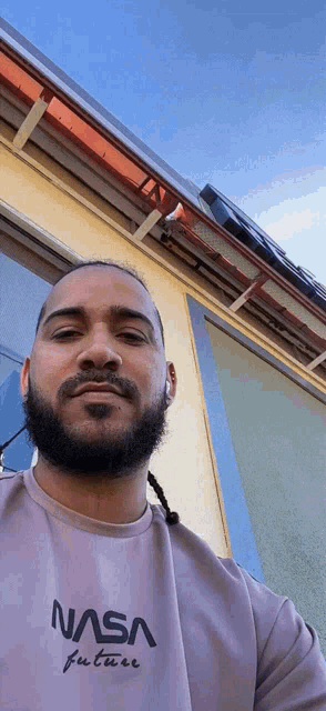 a man with a beard is wearing a nasa future sweatshirt