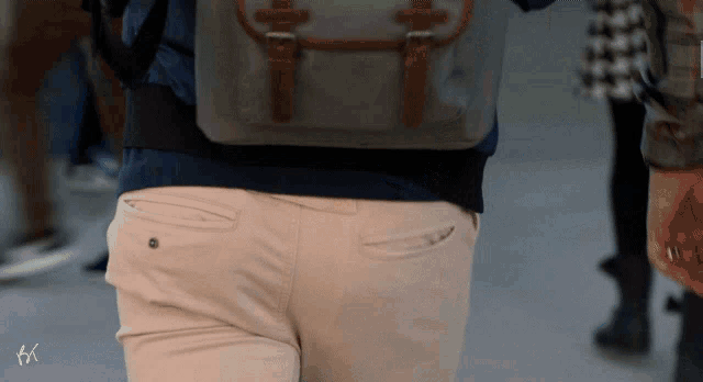 a person wearing khaki pants and a backpack is walking