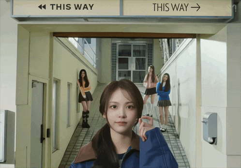 a woman standing in front of a sign that says this way