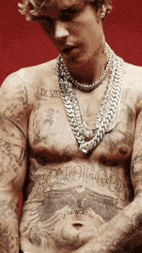 justin bieber has a lot of tattoos on his chest and torso .