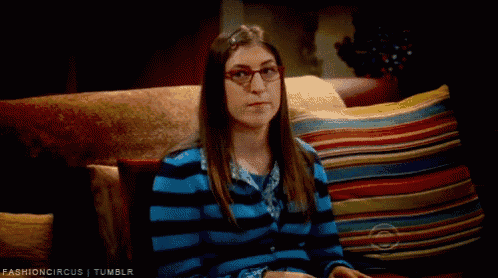 a woman wearing glasses is sitting on a couch with colorful pillows and the words fashioncircus tumblr below her