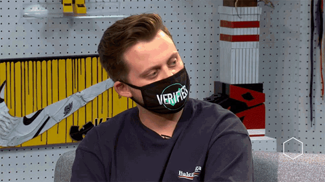 a man wearing a black mask that says veritas