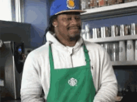 a man wearing an apron and a starbucks hat