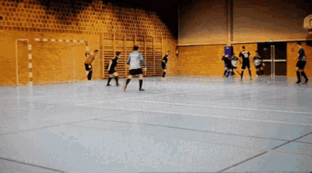 a group of soccer players are playing in a gym and one of them is wearing a shirt that says ' a '