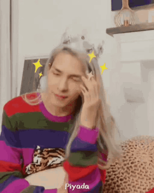 a person wearing a rainbow colored sweater with a tiger on it and a crown on their head