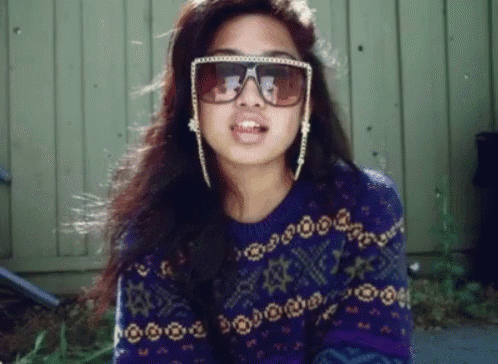 a woman wearing sunglasses and a purple sweater with stars on it