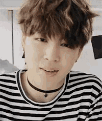 a close up of a person wearing a striped shirt and choker