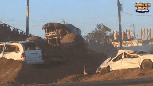 a monster truck is jumping over a white van at a monster truck show