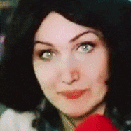 a close up of a woman 's face with green eyes and black hair