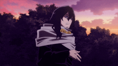 a man with long hair and a scarf around his neck stands in front of a sunset