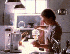 a man is pouring something into a glass in a kitchen