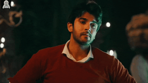 a man in a red sweater is holding his head