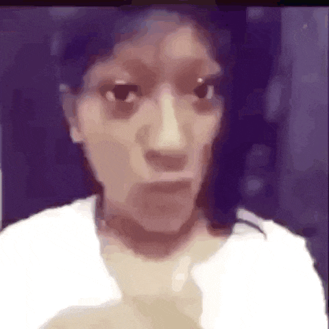 a woman in a white shirt is making a funny face in a video .