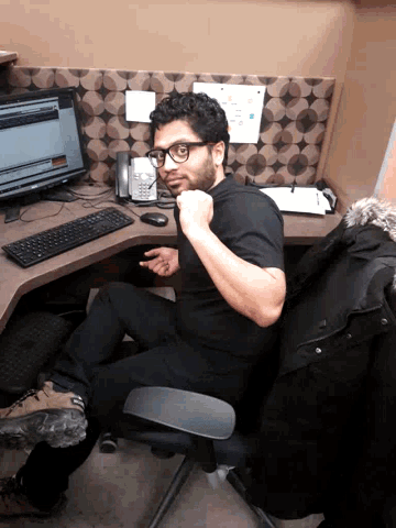 a man sitting at a desk with a telephone and a computer
