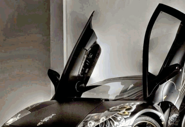 a black sports car with the door open and a floral design on the side