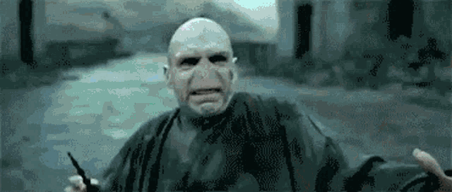 voldemort from harry potter is holding a wand in his hand .