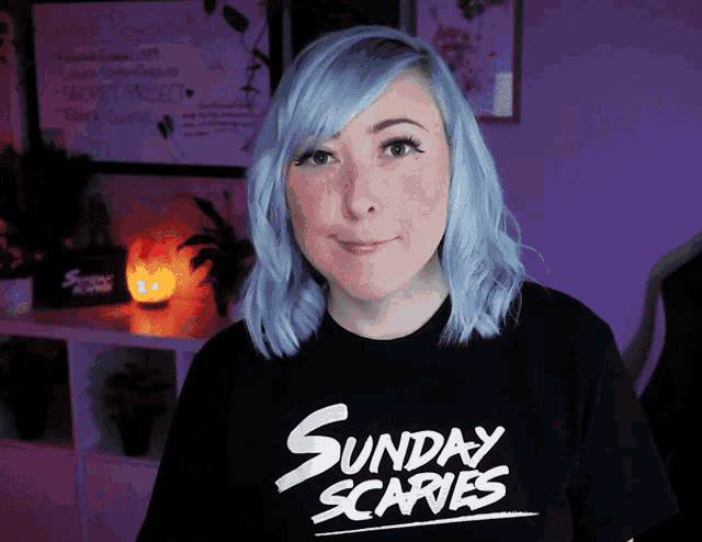 a woman with blue hair wears a sunday scaries shirt