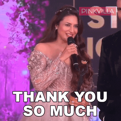 a woman in a white dress is holding a microphone and says thank you so much
