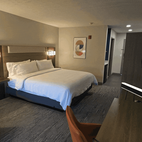 a hotel room with a king size bed and a painting on the wall