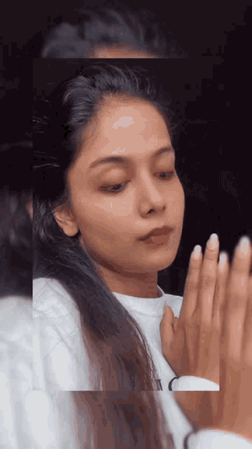 a woman looking at herself in a mirror with her hands on her chest