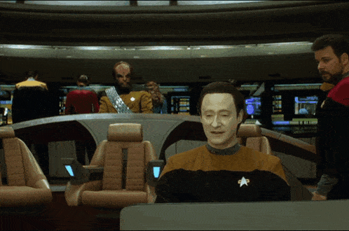 a man in a yellow shirt with a star on it sits at a desk