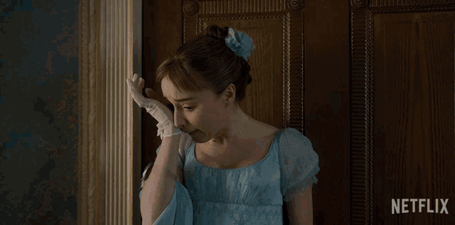 a woman in a blue dress is standing in front of a door that says netflix