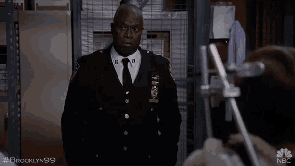 a man in a police uniform pointing at the camera with the hashtag brooklyn99