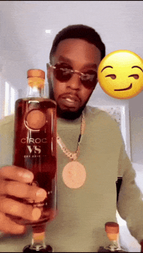 a man is holding a bottle of ciroc vs.
