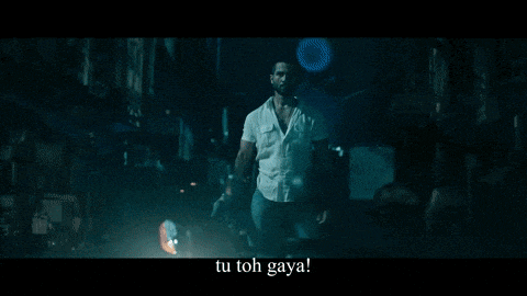 a man in a white shirt is standing in a dark room with the words tu toh gaya below him